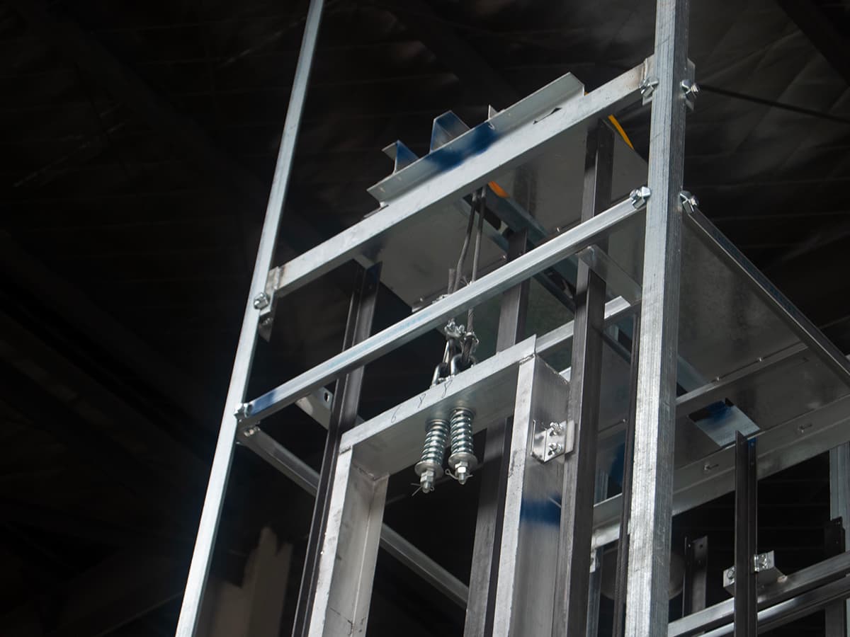 Dumbwaiter guide rails and frame being installed inside a prepared shaft