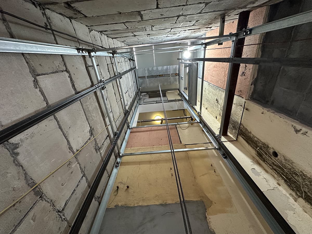 Dumbwaiter installation site: shaft with steel ropes running through multiple floors